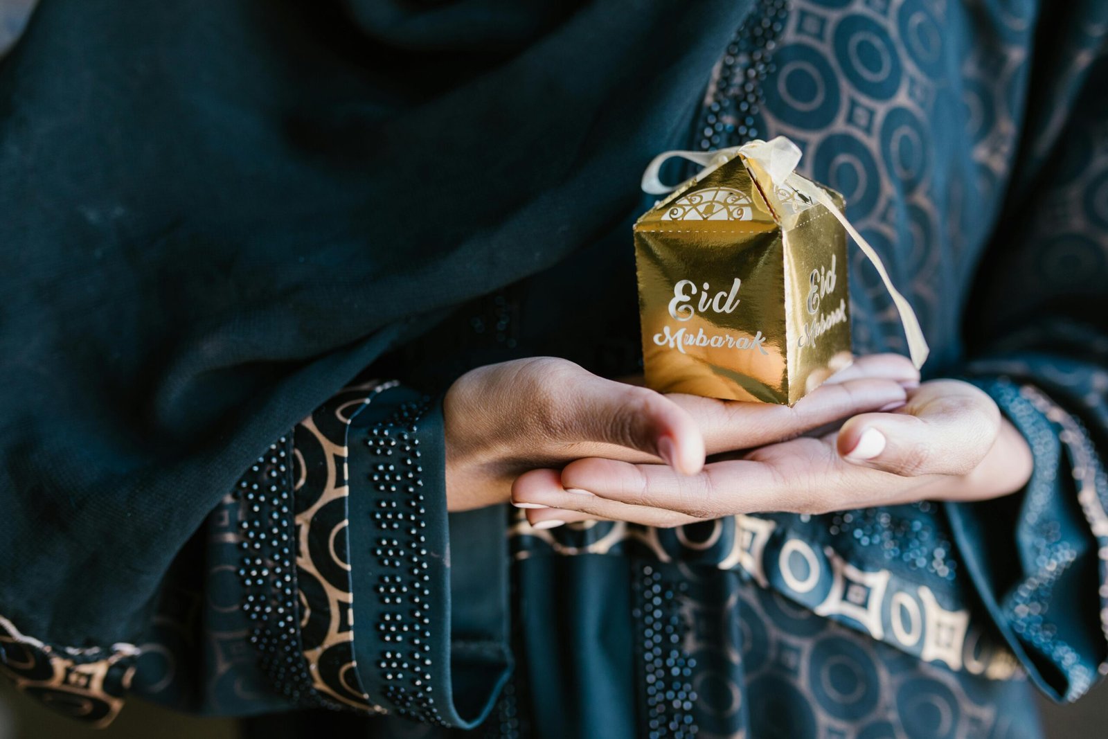 Elegant Eid Mubarak gift held by a Muslim woman, symbolizing celebration and joy.